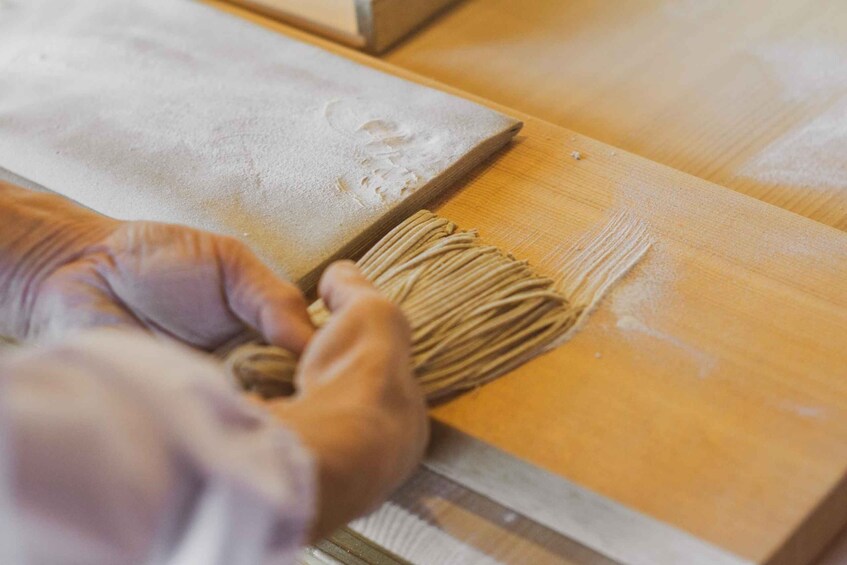 Hands applying flour to a wooden surface. 4