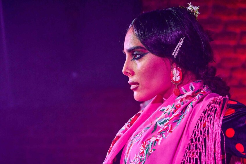 A person wearing a pink garment with floral embroidery. 1