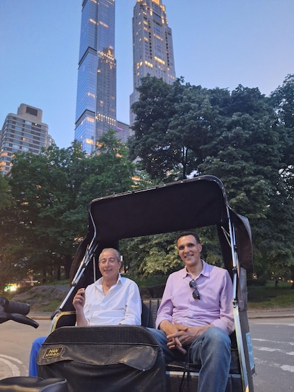 Two people in a convertible car with a cityscape in the background. 3