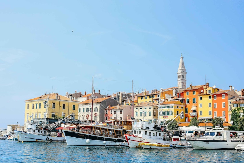 A harbor with colorful buildings and a prominent tower. 1