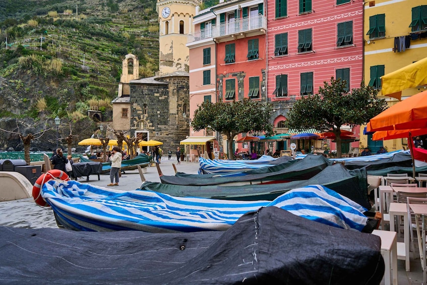 Colorful buildings, a clock tower, and covered boats on a waterfront. 2