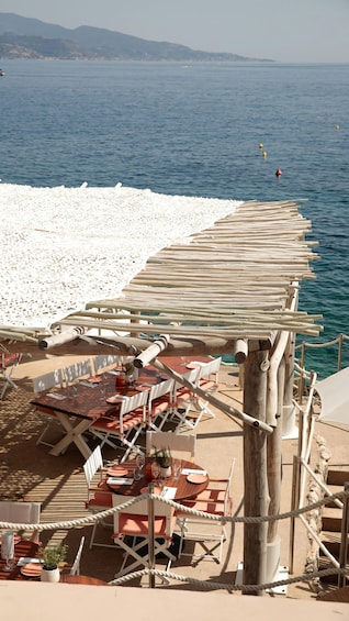 A seaside restaurant with outdoor seating overlooking the ocean. 3
