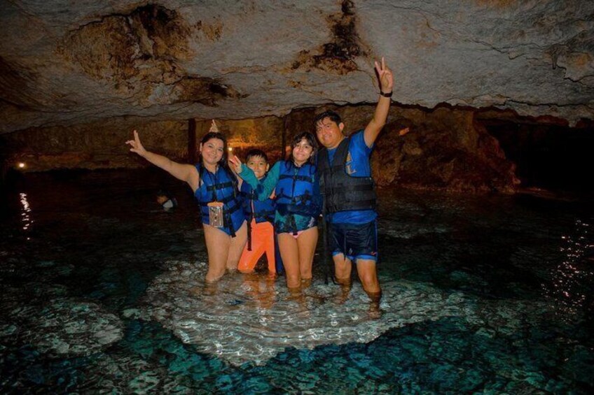 A group of people in a cave with water at the bottom. 4