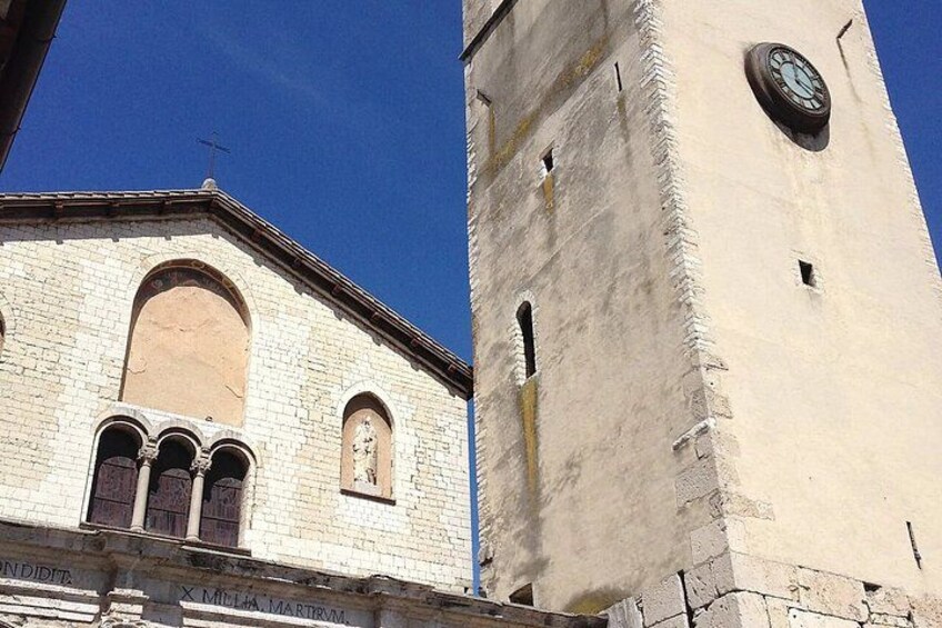 A historic building with a clock tower, arched windows, and inscriptions on the facade. 3