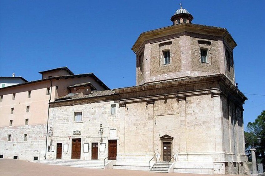 A historic building with a central tower, a large arched doorway, and a staircase leading to the entrance. 5