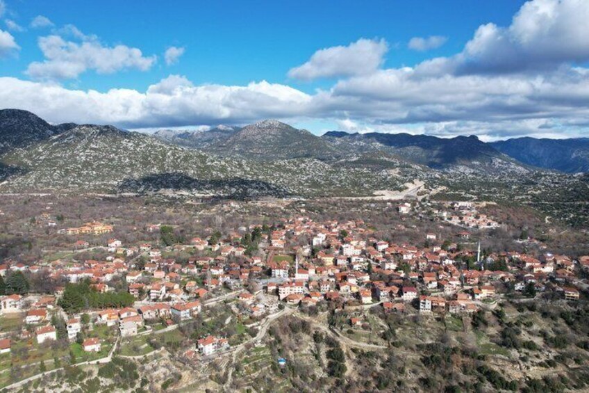 A town nestled in a valley with mountains in the background. 1
