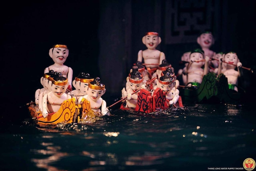 A puppet theater performance with multiple puppets in a water scene. 4