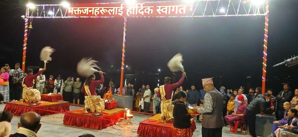 A traditional dance performance on a stage with a crowd watching. 4