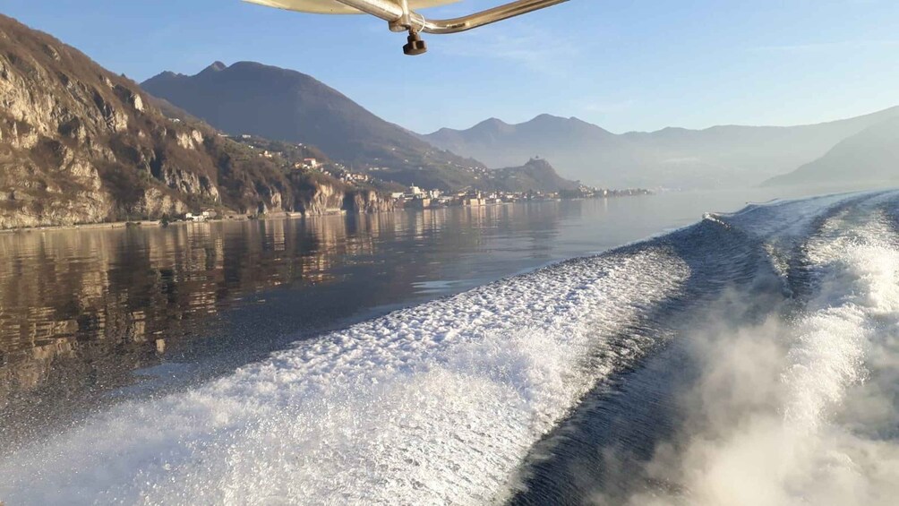 A boat moving through a river with mountains in the background. 5