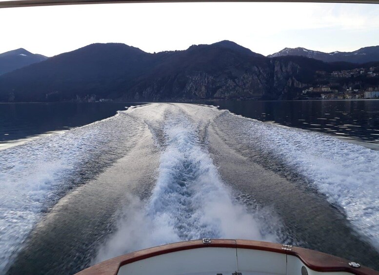 A boat moving through a lake with mountains in the background. 3