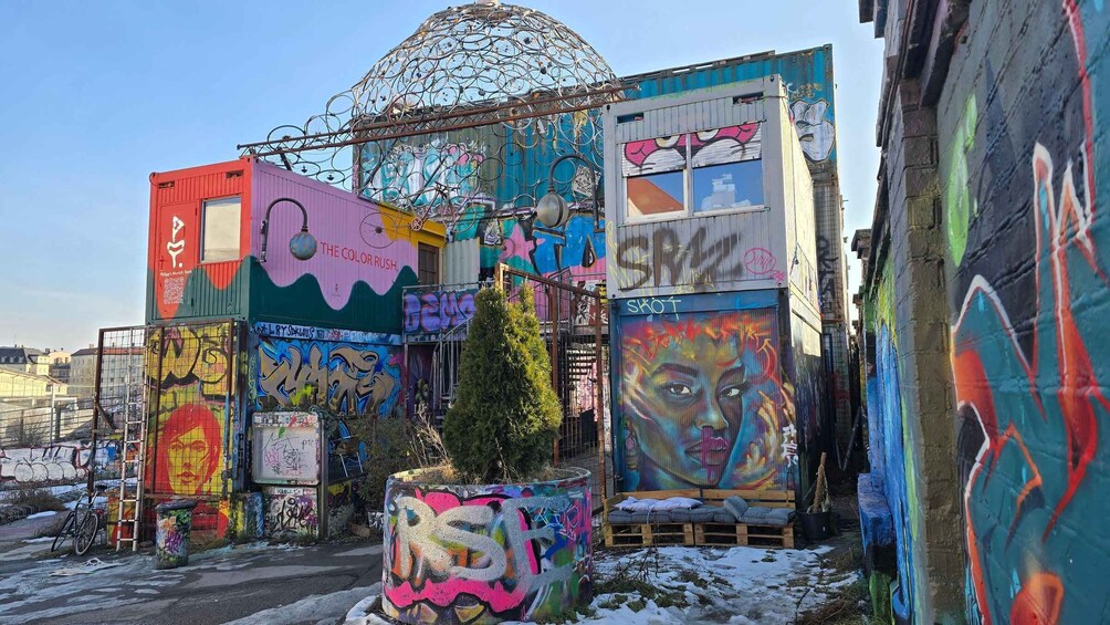 A colorful urban art installation with graffiti and a metal structure. 4
