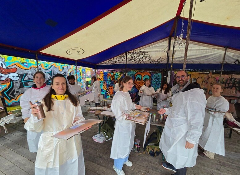 A group of people in a tented area with colorful graffiti on the walls. 2