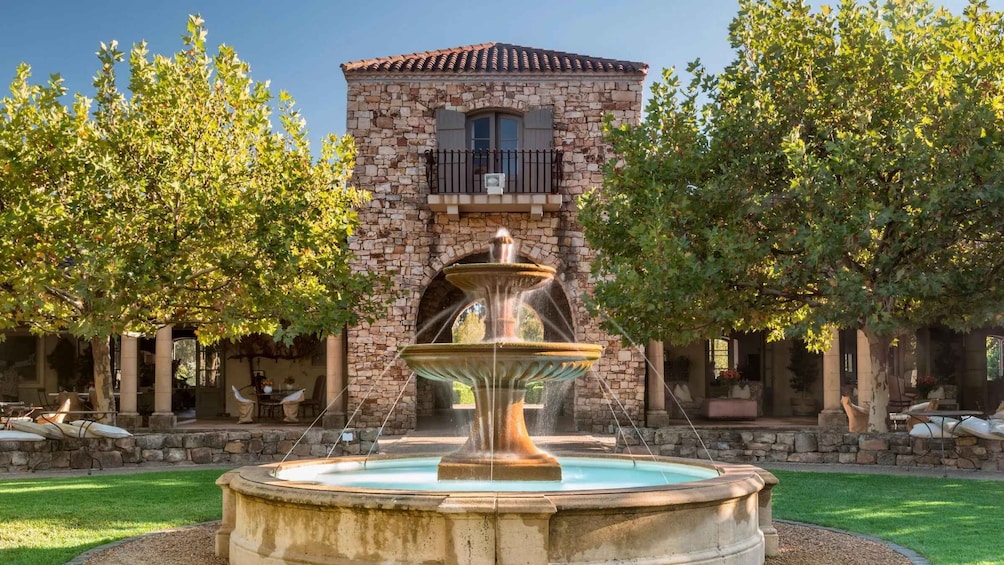 A stone building with a fountain in front. 1