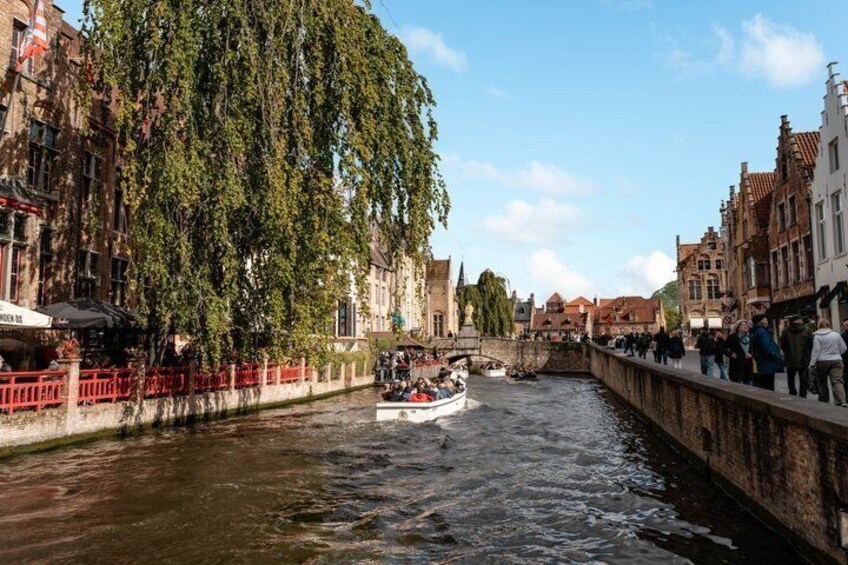 A canal with a boat, red fences, and historic buildings. 3