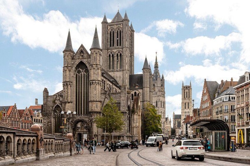 A historic cathedral with pointed spires, a cobblestone street, and a tram. 3