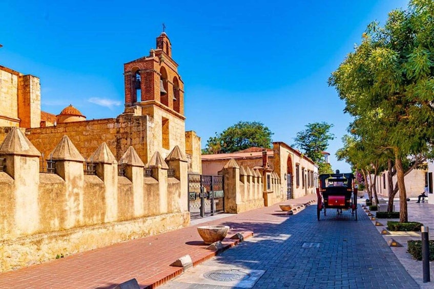 A historic street with a bell tower, cobblestone path, and a horse-drawn carriage. 5