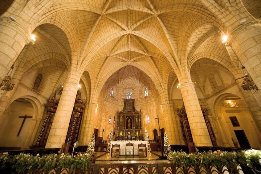 A cathedral interior with high vaulted ceilings, a central altar, and stained glass windows. 3