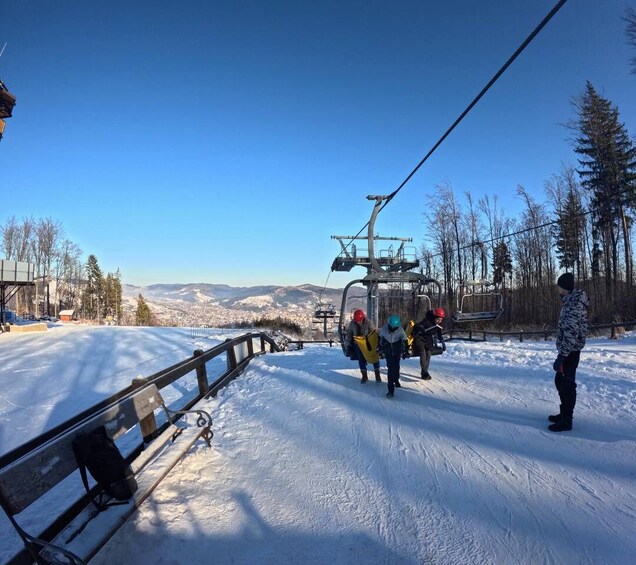 A ski lift with skiers and a chairlift in a snowy mountainous area. 2