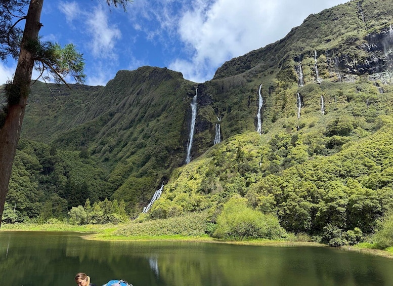 A mountainous landscape with multiple waterfalls and a calm lake. 4