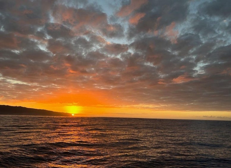 A sunset over a body of water with a cloudy sky. 1