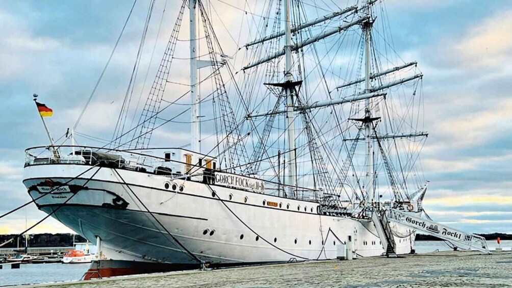 A large sailing ship docked at a harbor with multiple masts and rigging. 4