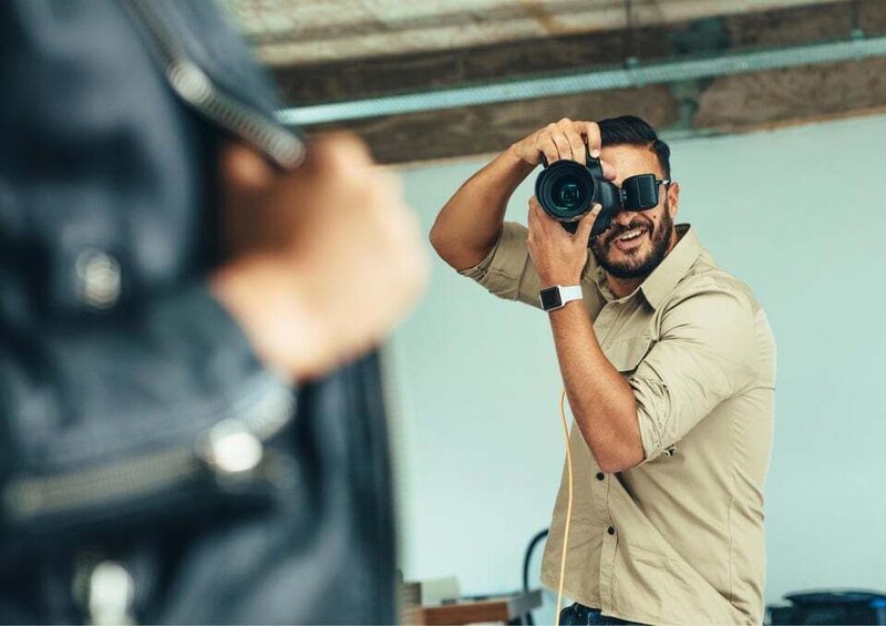 A person taking a photograph with a camera. 1