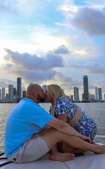 A couple sitting on a boat with a city skyline in the background. 3