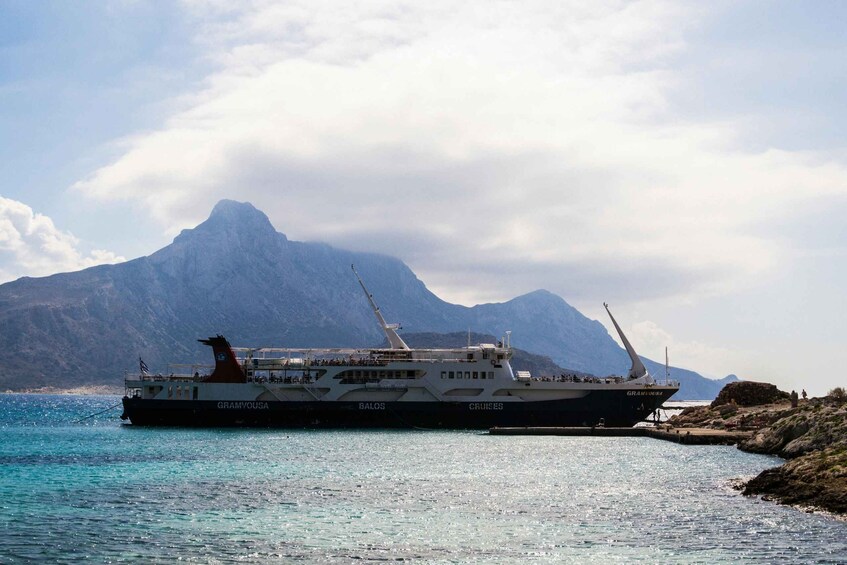 A ferry named 'GRAMYOUSA' docked at a harbor with a mountainous backdrop. 4