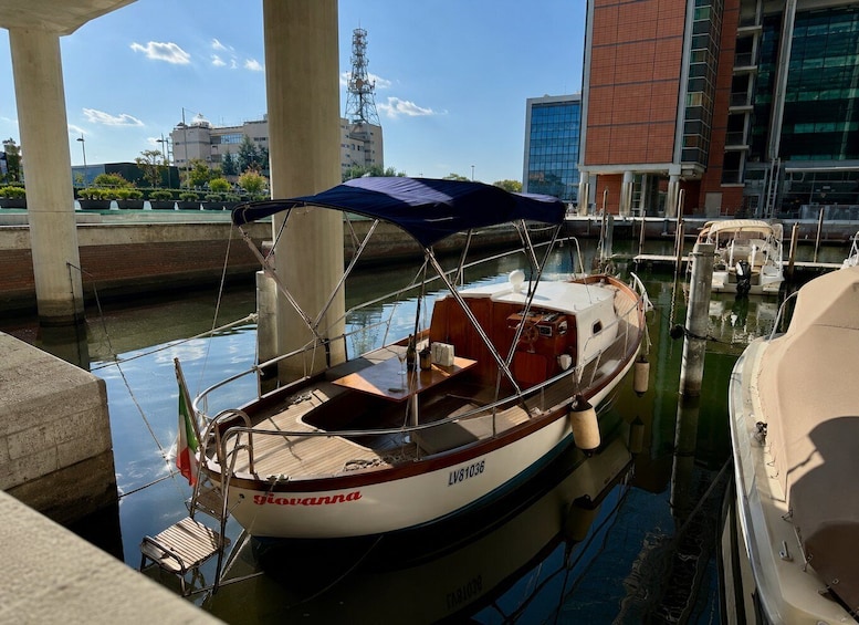 A boat named 'giovanna' docked at a marina with a cityscape in the background. 2
