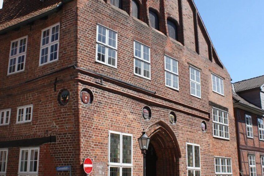 A red brick building with multiple windows and a large arched entrance. 3