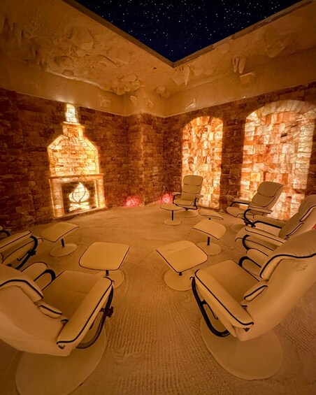 A room with stone walls, a fireplace, and reclining chairs. 1