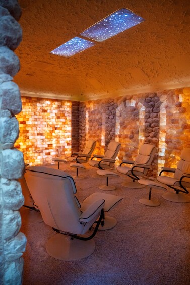 A room with stone walls, a brick wall with a warm light, and several reclining chairs. 3