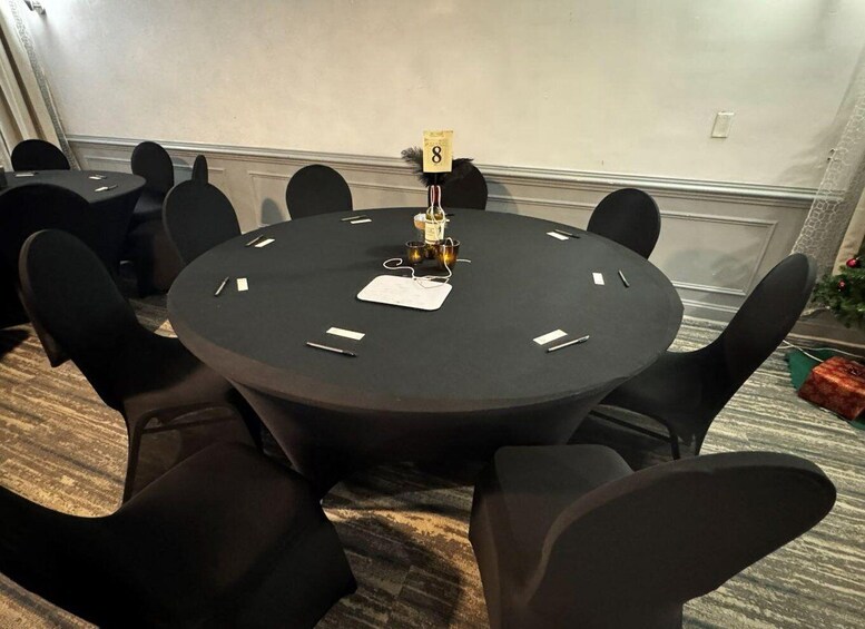 A conference room with a round table, black chairs, a whiteboard, and a small Christmas tree. 2