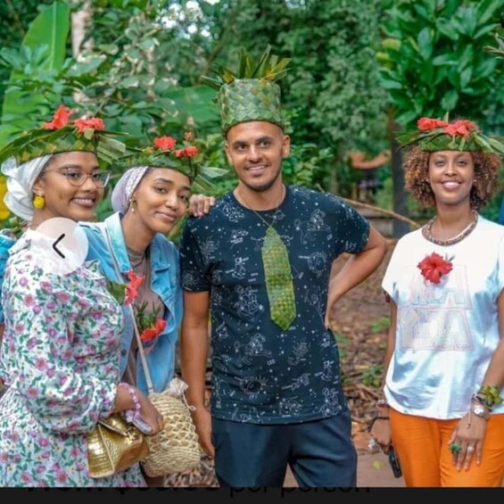 Four people outdoors, wearing traditional headgear with red flowers. 2