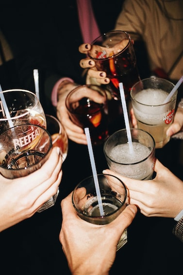 A group of people holding glasses with straws, some with ice and fruit, and one labeled 'BEEFAT.' 2