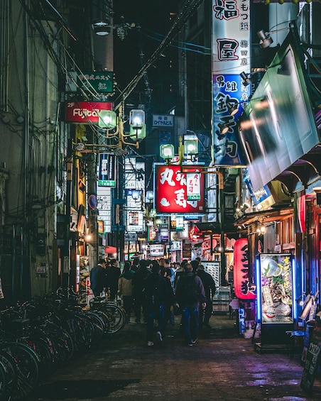 A bustling urban street at night with neon signs, bicycles, and pedestrians. 3