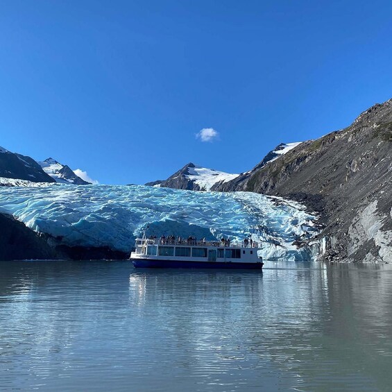 A boat on a glacier with mountains in the background. 2