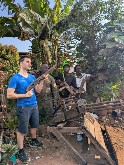 A group of people standing around a makeshift wooden structure in a garden with banana trees. 2