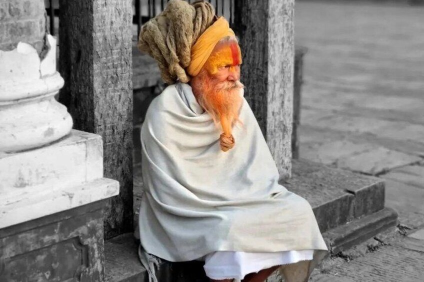 A person sitting on steps near a stone structure. 1