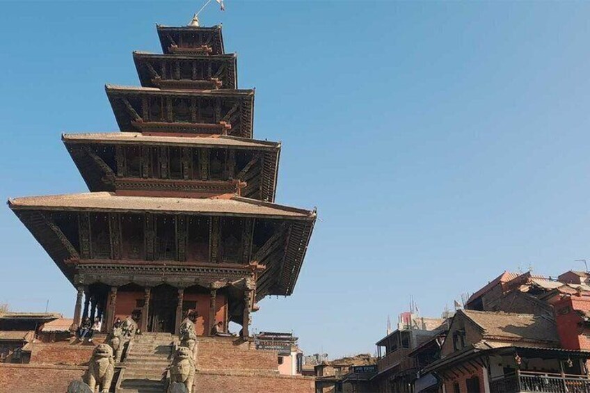 A multi-tiered pagoda with a flag on top, surrounded by traditional buildings. 5