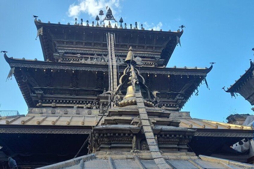 A traditional multi-tiered temple with ornate carvings and a central statue. 4