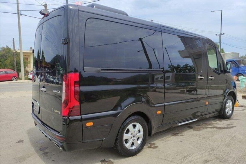 A black van parked on a concrete surface with visible wheel arches and a rear license plate. 3