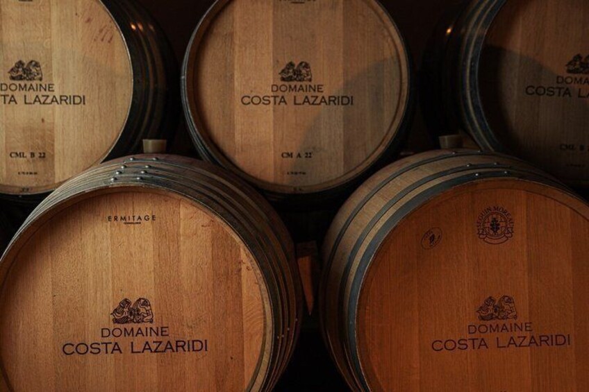 Wooden wine barrels with 'Domaine Costa Lazaridi' branding. 4