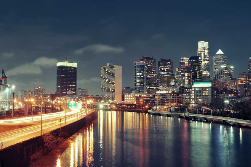 A nighttime cityscape with illuminated skyscrapers and a river reflecting lights. 2