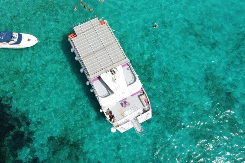 A boat docked at a pier with clear turquoise water. 1