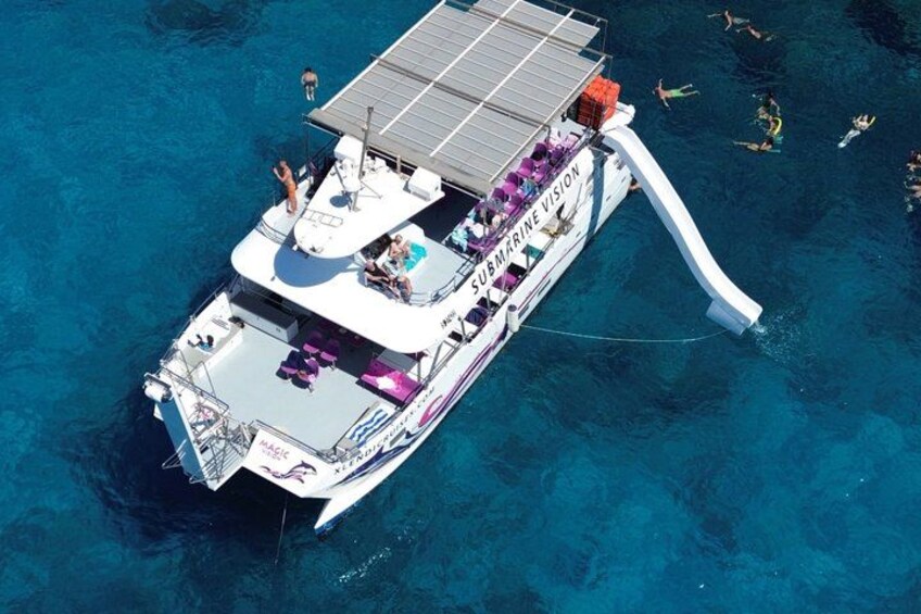 A boat with a solar panel and a slide for people to enter the water. 2