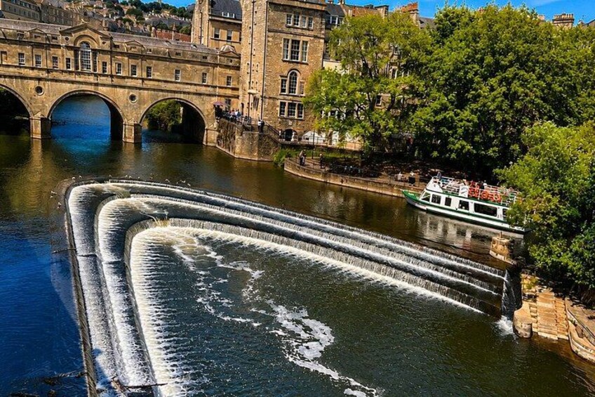 A river with a boat, a bridge, and a building. 3