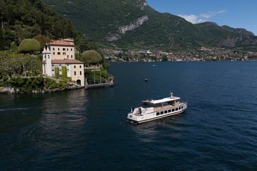 A lake with a boat and a building surrounded by mountains. 5