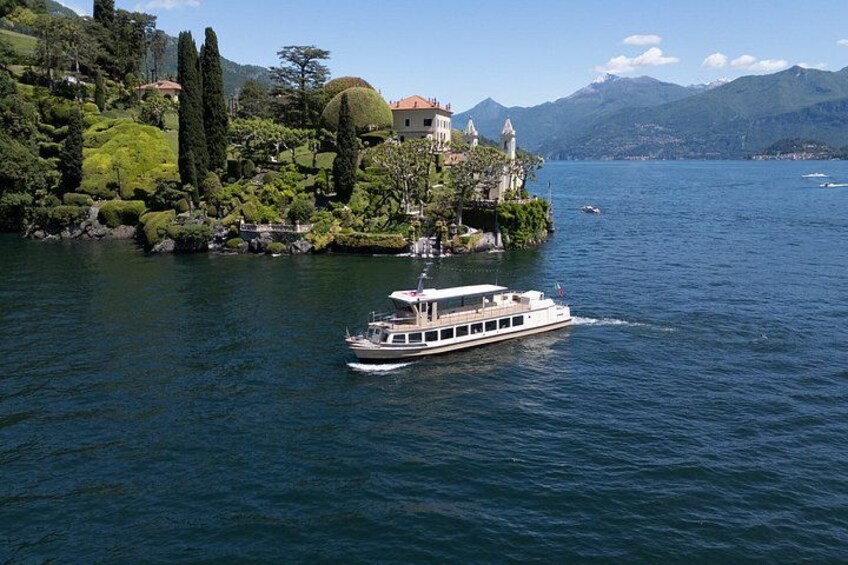Un bateau sur un lac, avec un château perché sur une colline et des montagnes en arrière-plan. 3