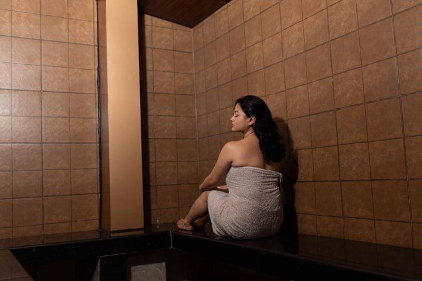 A person sitting in a tiled room. 4